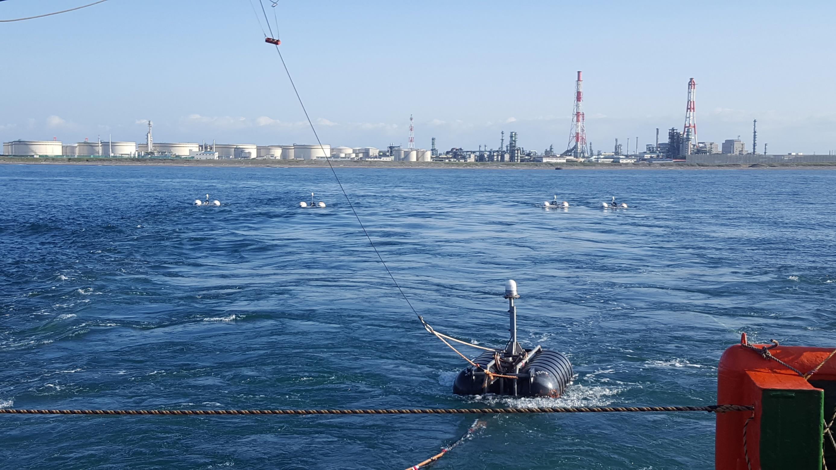 IMAGE OF SEISMIC SOURCE FLOATING ON THE WATER WITH THE TOMAKOMAI PORT IN THE DISTANCE