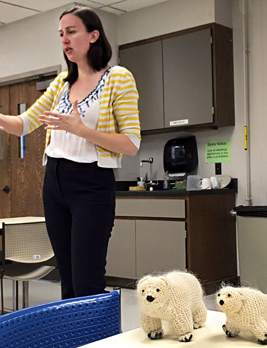 Caroline Reck talks with polar bear puppets in front of her.