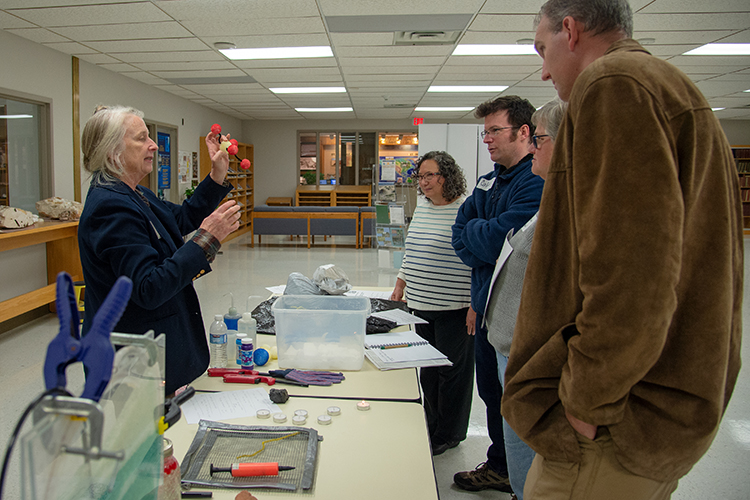 Susan Hovorka shows participants around a table of demonstrations, the molecular structure of CO2