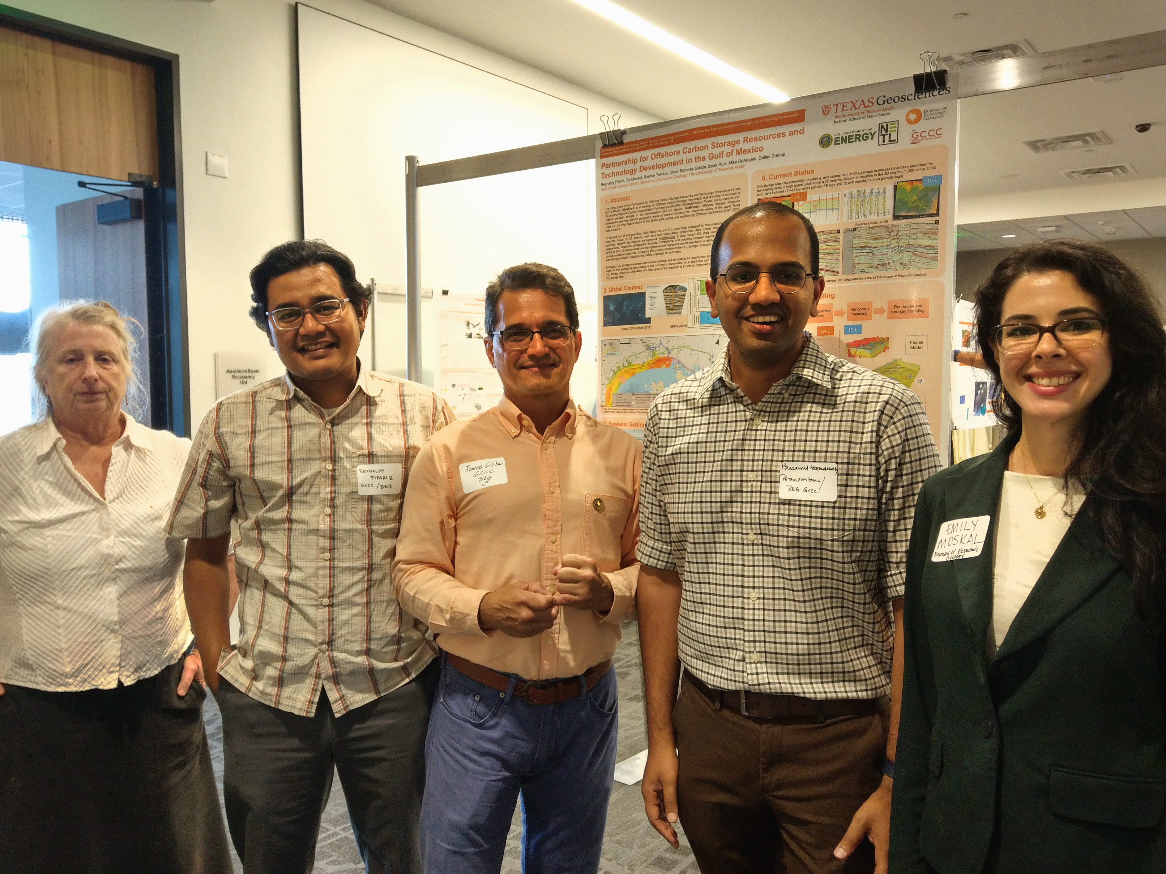 Five GCCC researchers stand in front of one of the posters presented at the expo