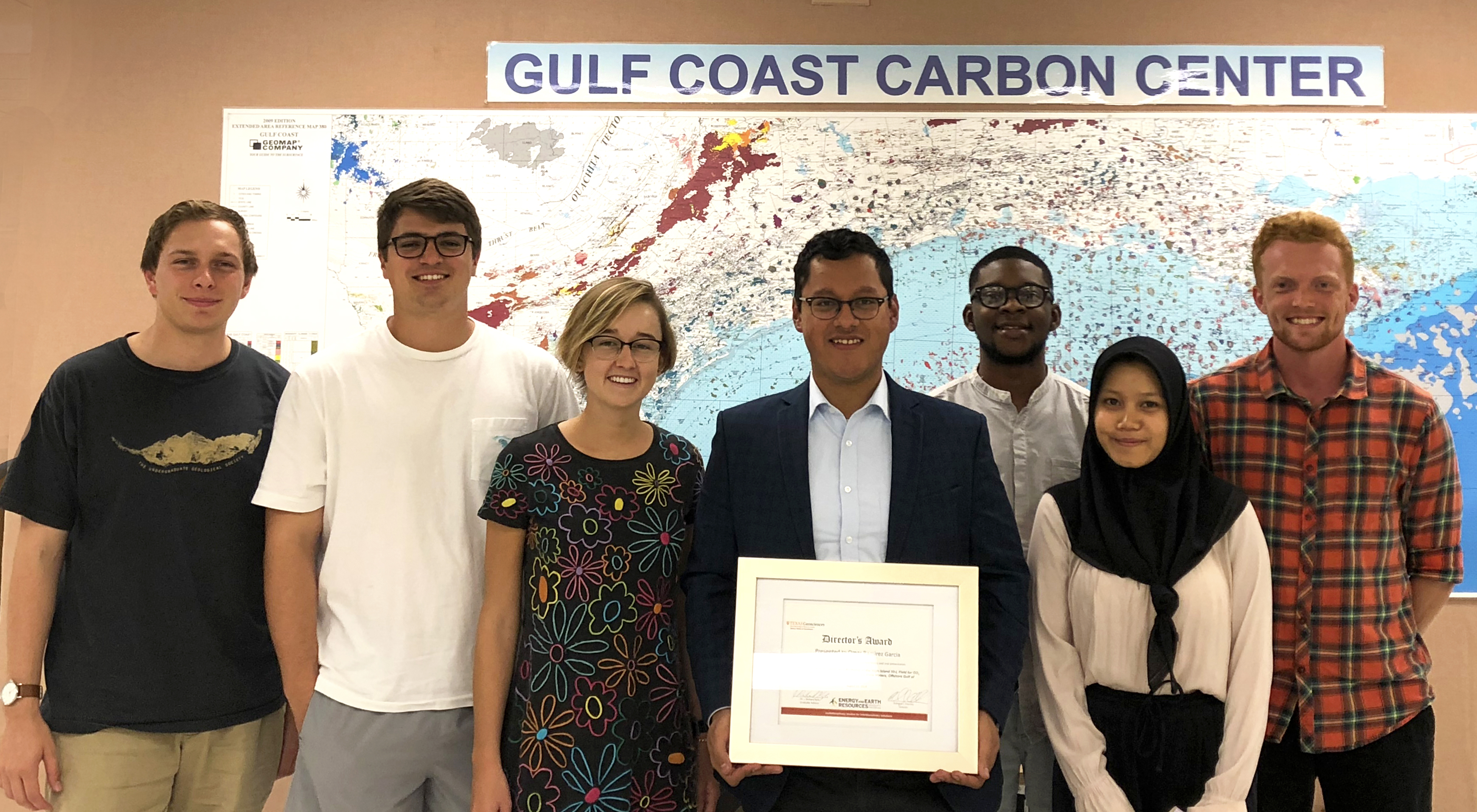 Omar stands in the middle of the incoming master's graduate students with his director's award for excellent thesis and Margaret, an undergraduate researcher
