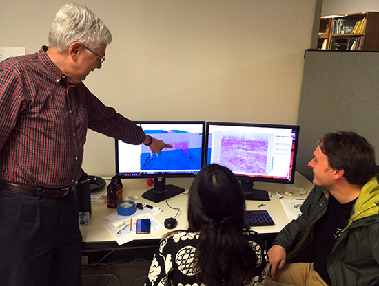 photo of rob finley pointing to the computer monitor of seismic data and subsurface models